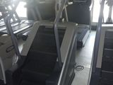 deux tapis de course dans une salle de sport, avec un homme debout sur l'un d'eux