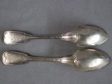two spoons that are sitting next to each other on a table