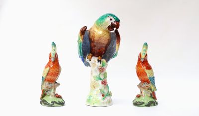 three figurines of parrots sitting on top of each other