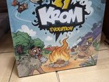 La boîte du jeu « Mom Evolution » est posée sur une boîte en carton.