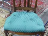 a chair with a blue seat on a rug in a room