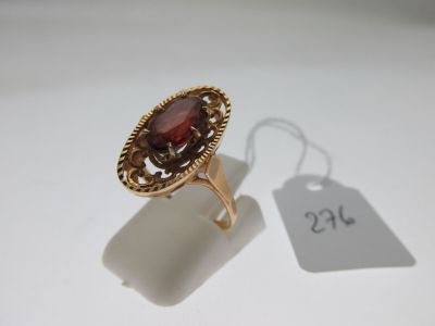 a close up of a gold ring with a red stone on it