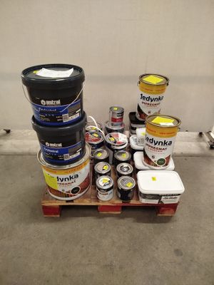 Plusieurs pots de peinture sont empilés sur une palette dans un entrepôt