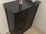 une armoire noire surmontée de deux tiroirs