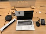 a laptop computer sitting on a desk with a lot of accessories
