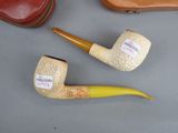 three different types of pipes on a table next to a case