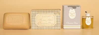 une image représentant un flacon de parfum à côté d'un savon et d'un pain de savon
