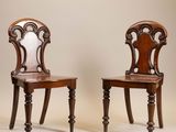 deux chaises en bois avec un dossier et des pieds sculptés, l'une avec une assise sculptée et l'autre avec un dossier sculpté