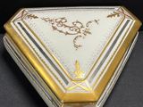 a white and gold box on a black surface