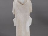 figurine of a man in a white robe and a hat on a wooden base
