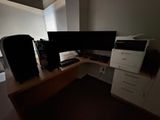 a computer desk with two monitors and a printer on it