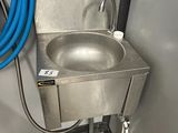 un évier en inox auquel est raccordé un tuyau bleu