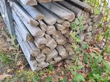 a pile of wood sitting on the ground next to a fence