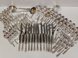 a lot of silver spoons and spoons on a table