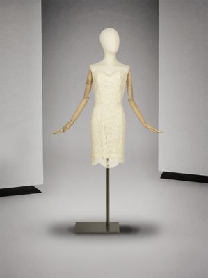 une photo d'un mannequin vêtu d'une robe blanche, posé sur un socle