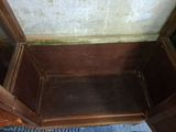 a wooden chest with a door open on a blue rug