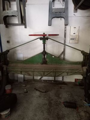 une photo d'un établi dans un garage, avec des outils accrochés au mur