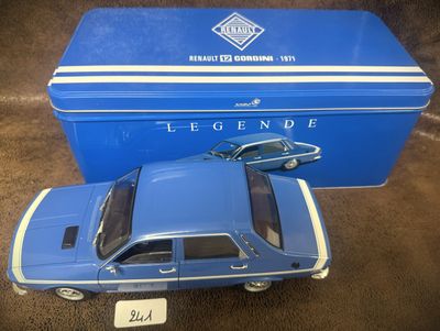 La petite voiture bleue est posée à côté d'une boîte bleue.