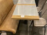 une table avec un banc et des chaises dans une pièce