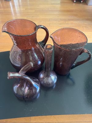 three brown vases sitting on a table with figurines