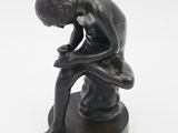 statue représentant un homme assis sur un tabouret, la tête entre les mains