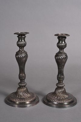 pair of antique silver candlesticks on a grey background