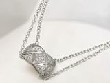 collier avec un pendentif en diamant sur une chaîne, posé sur un fond blanc