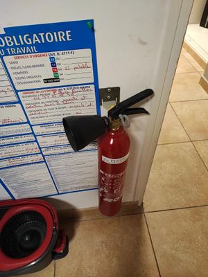a red fire extinguisher next to a white door