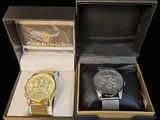 two watches sitting in a box on a black surface