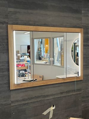 un miroir accroché au mur dans une pièce où se trouvent une table et des chaises