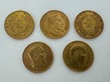 four gold sovereigns, one of which has a crown on it