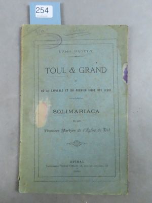 an old book sitting on top of a white table next to a blue tag