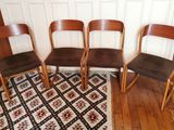 quatre chaises en bois alignées sur un tapis