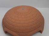 a close up of a clay object on a white surface