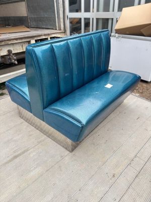 un banc bleu posé sur un plancher en bois
