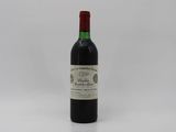 a bottle of red wine sitting on top of a white table