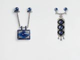 two pieces of jewelry are displayed on a white surface