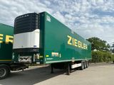 un semi-remorque vert garé sur un parking