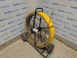 a yellow hose sitting on a cart in a room
