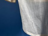 a close up of a white shirt hanging on a blue wall