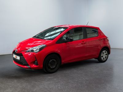 une Toyota Yaris rouge garée dans une pièce blanche