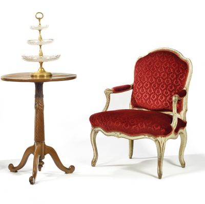 two chairs and a table with a cake stand on top of it