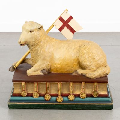 a statue of a sheep with a flag on top of a book