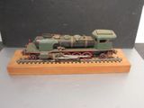 une petite maquette de train posée sur un socle en bois