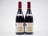 deux bouteilles de vin rouge posées l'une à côté de l'autre sur une surface blanche