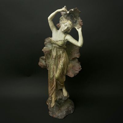 statue d'une femme tenant un éventail sur fond noir