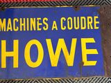 un panneau bleu et jaune sur lequel on peut lire « Machines A Courre Howe »