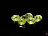 some very pretty green crystal stones on a black surface