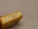 a hand holding a yellow box with a label on it