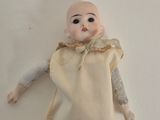 a doll that is laying on the floor next to a white wall
